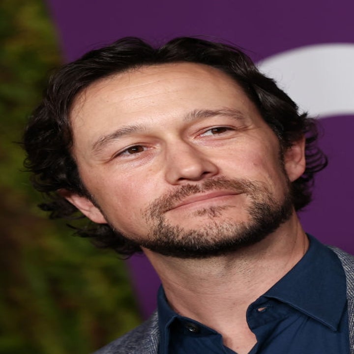 A person in a blazer and shirt at a formal event, looking slightly to the side