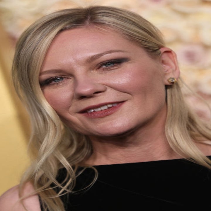 Person in elegant attire at an event, standing in front of a floral backdrop