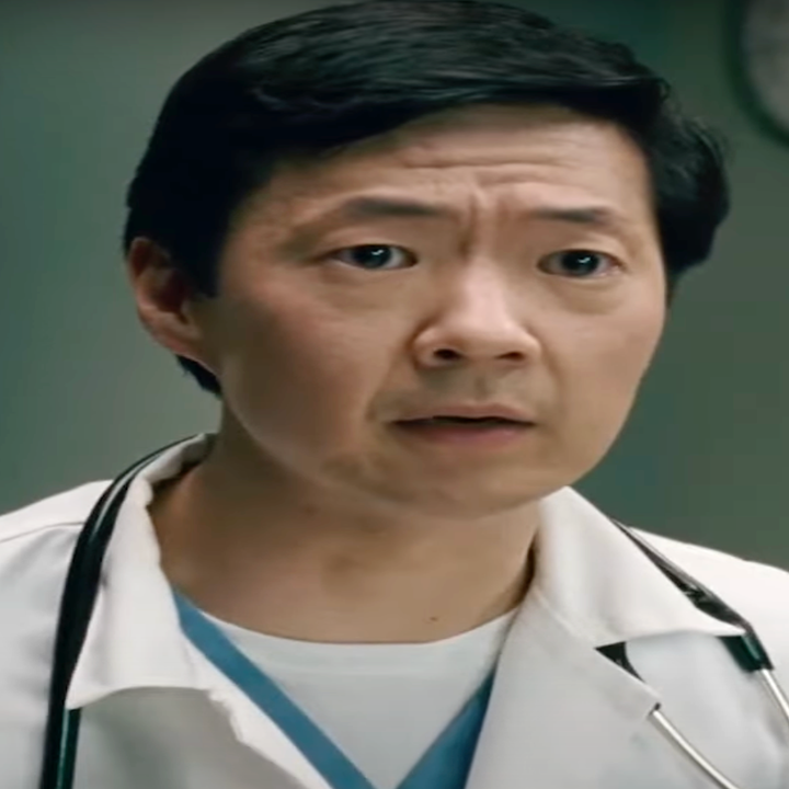 A person in a doctor's outfit with a stethoscope is in a room, looking concerned. They stand near a lamp and framed art