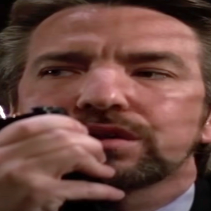 Person holding a walkie-talkie, looking to the side with a focused expression