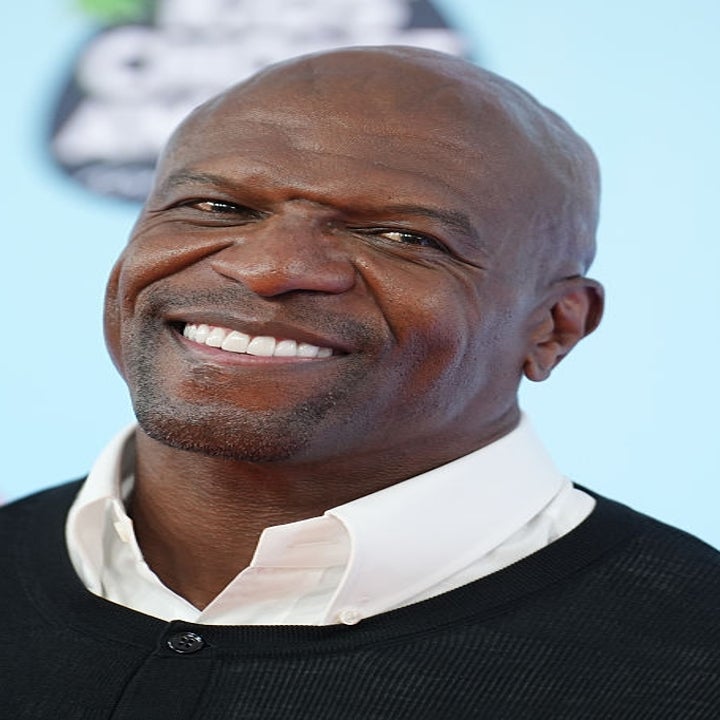 Person smiling at an event, wearing a collared shirt and sweater