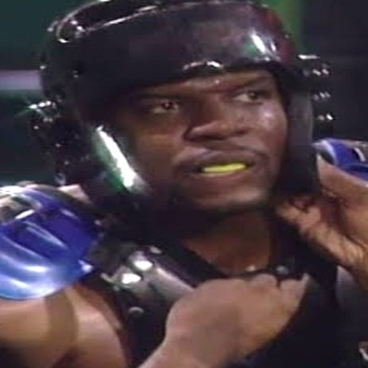 Person wearing protective sports gear and a helmet, sitting down, with a focused expression