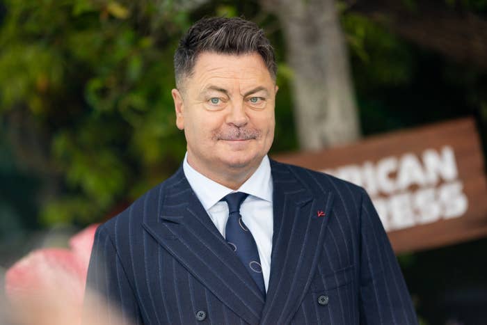 Person in a pinstripe suit and tie at an event, standing outdoors. Unidentified