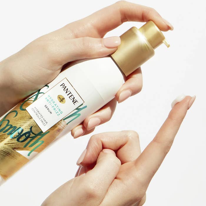Hands applying a pump of Pantene Pro-V Smooth hydrating manus pick onto a fingertip, showcasing merchandise usage