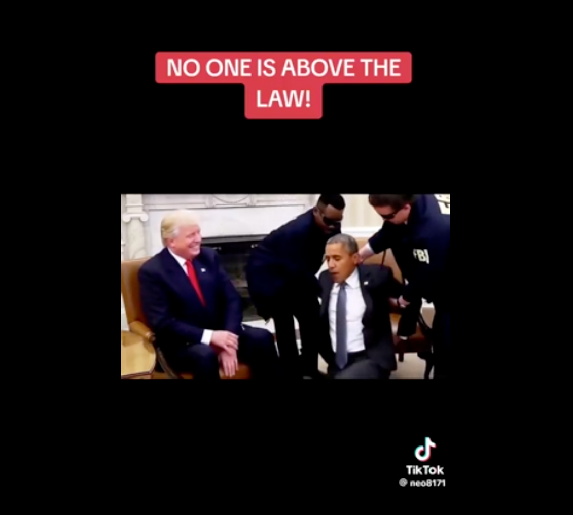 A person is seated while others wearing official attire arrest them. Text above reads, &quot;No one is above the law!&quot;