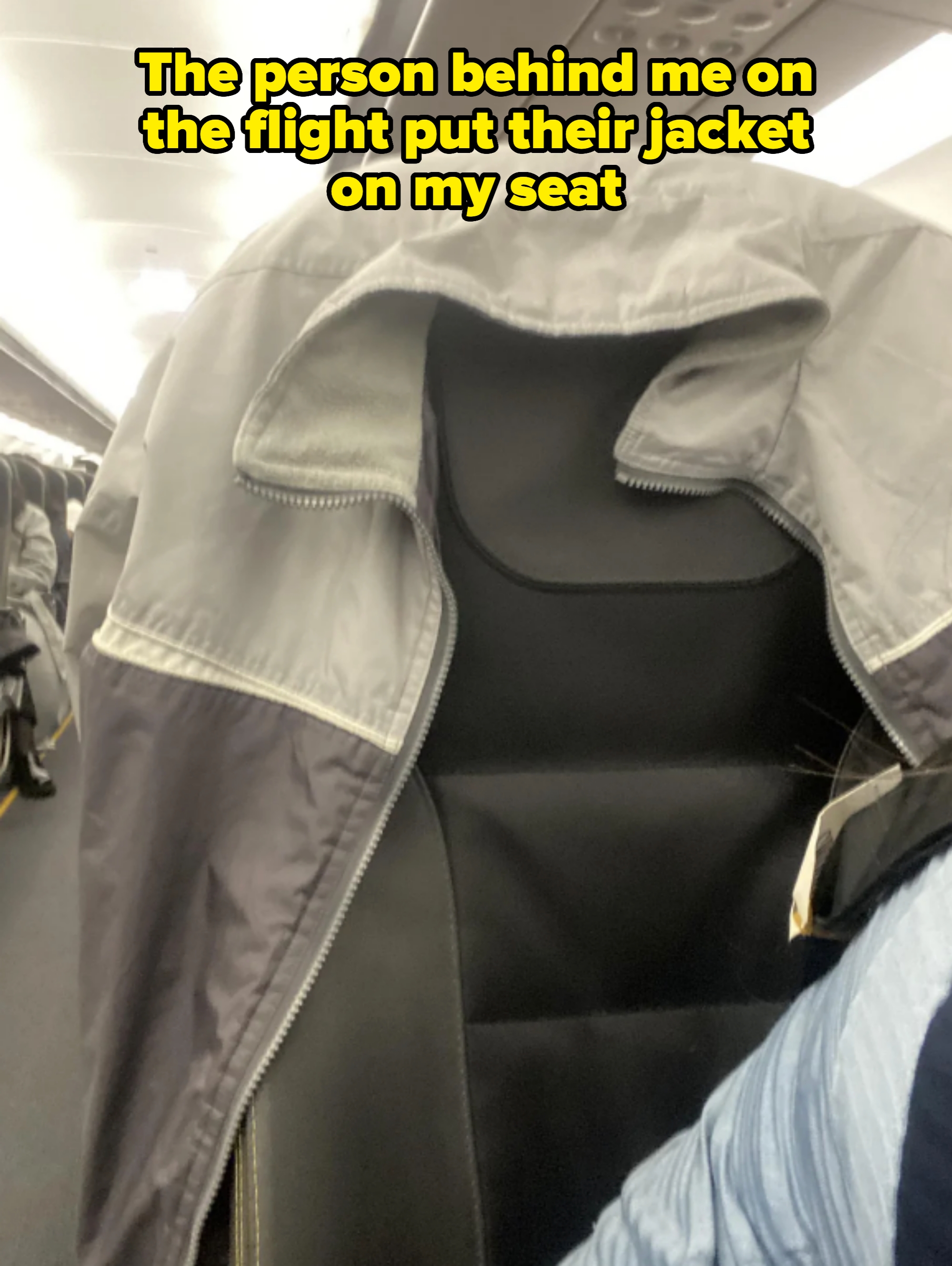 Jacket draped over the back of an airplane seat. Caption: &quot;The person behind me on the flight put their jacket on my seat&quot;