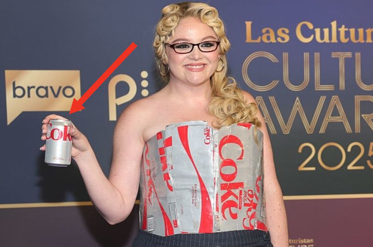 Meg Stalter wearing a dress made from diet coke packaging with a black skirt, holding a soda can, posing at Las Culturistas Culture Awards 2023