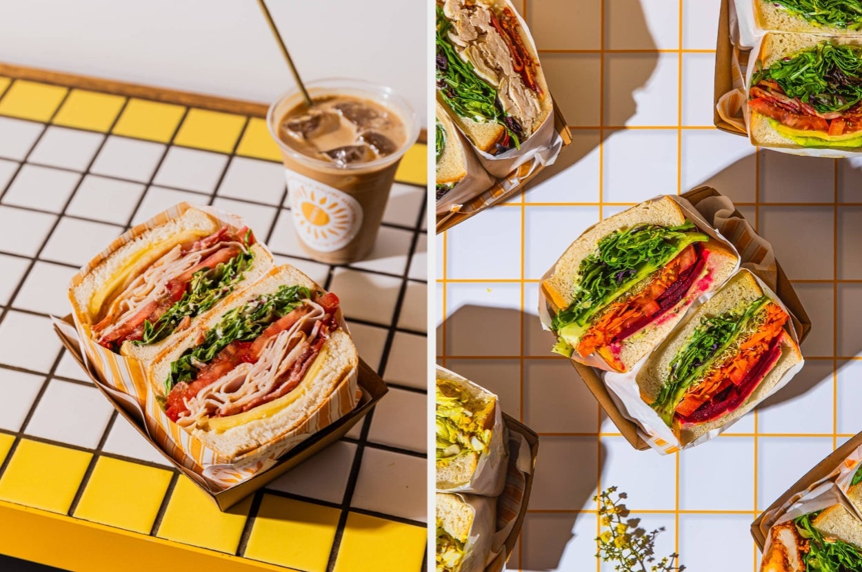 Various sandwiches filled with fresh greens, meat, and vegetables are on colorful tiled surfaces, accompanied by an iced coffee