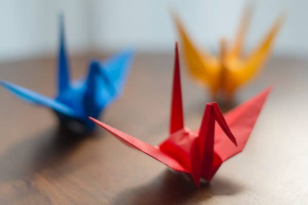 Three origami cranes on a surface.