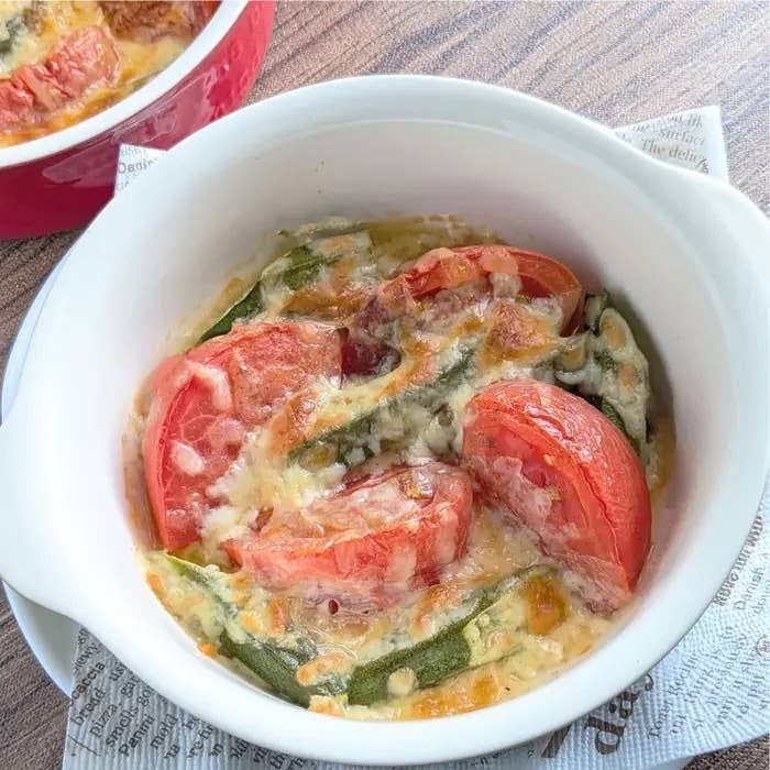 白い容器に入ったトマトと野菜のグラタン。