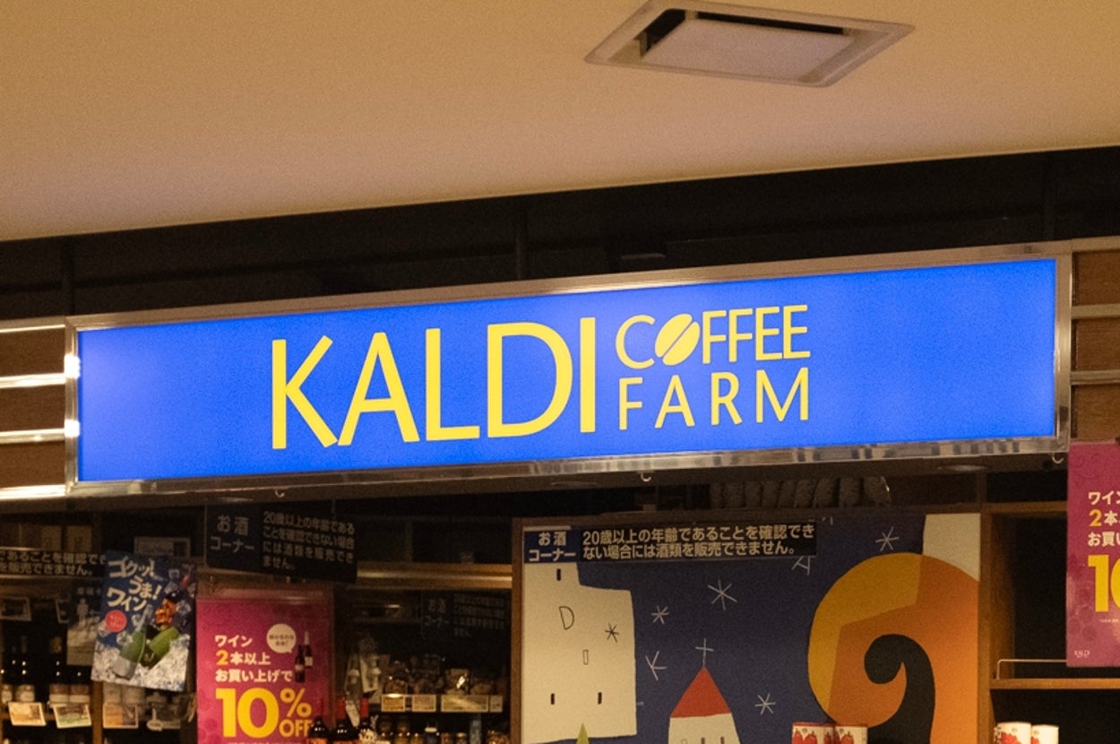 店舗の外観。コーヒーや輸入食品が棚に並び、特売のポスターが掛かっている。バスケットが店の入口に置かれている。
