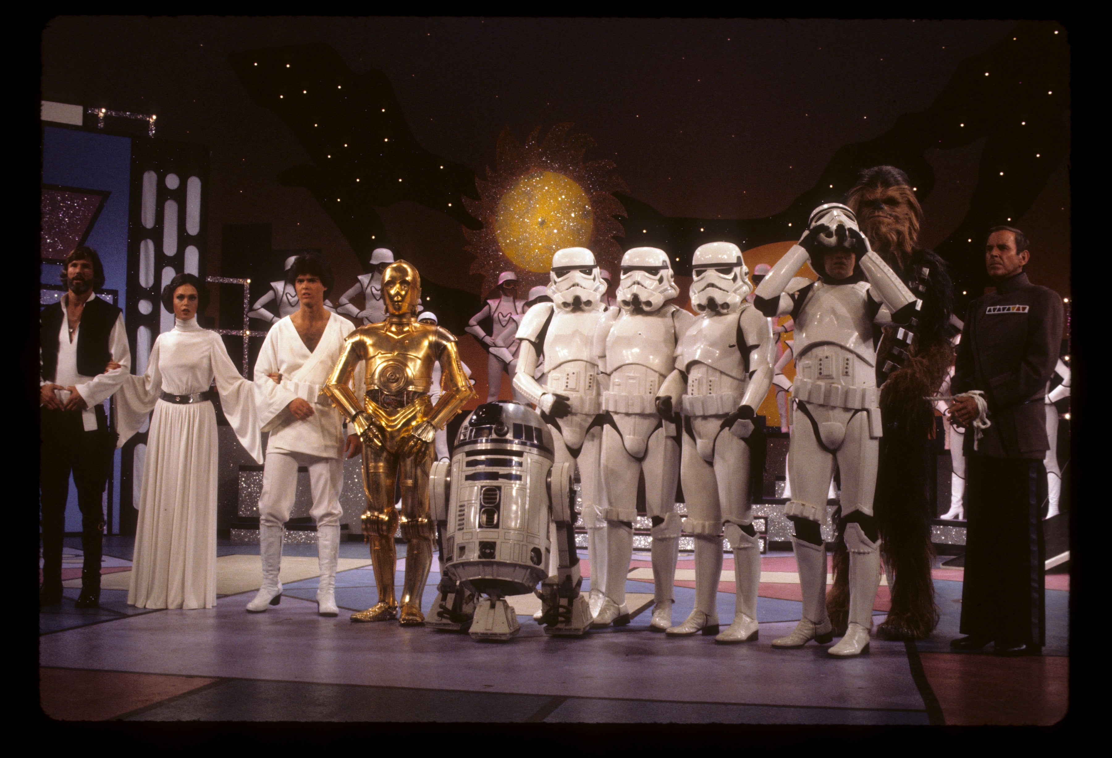 Actors successful  "Star Wars" costumes, including Leia, Luke, C-3PO, R2-D2, and Stormtroopers, airs  connected  a signifier    acceptable   resembling a space-themed environment