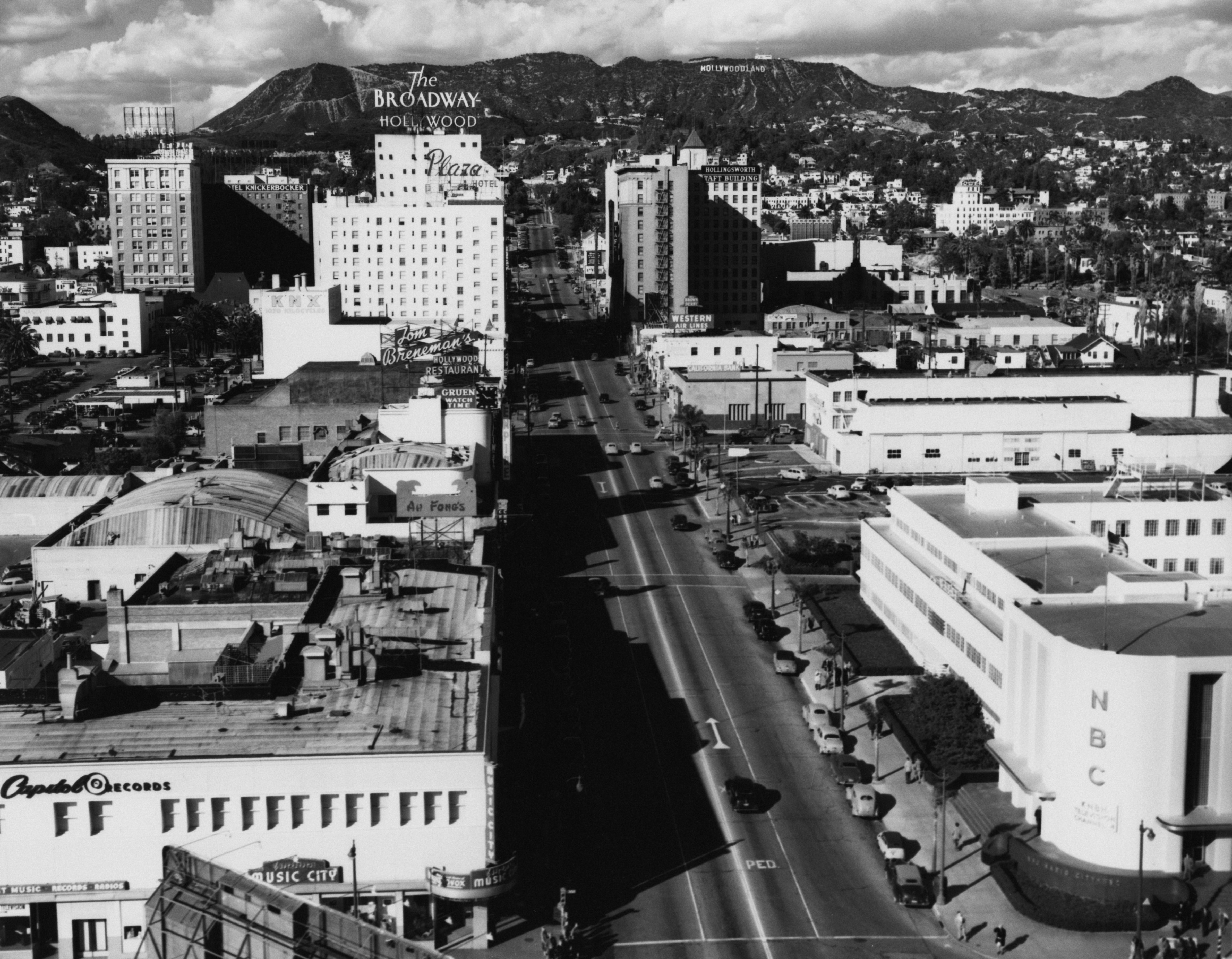 1950s aerial presumption of Hollywood Boulevard, showcasing iconic signs, buildings, and surrounding hills successful Los Angeles