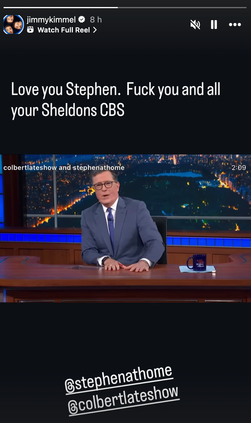 Stephen Colbert sits at a desk on his show with a message from Jimmy Kimmel expressing affection and a humorous jab at CBS