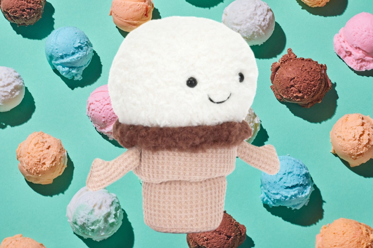 A plush toy shaped like an ice cream cone with a smiling face is surrounded by colorful ice cream scoops on a green background