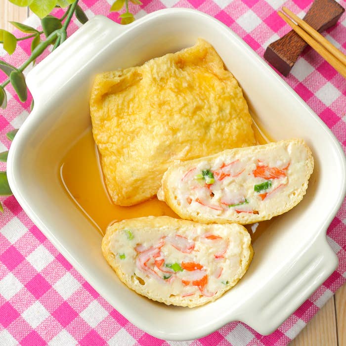 豆腐が詰まった揚げ物料理がトレーに盛られ、ピンクのチェック柄クロスの上に置かれています。