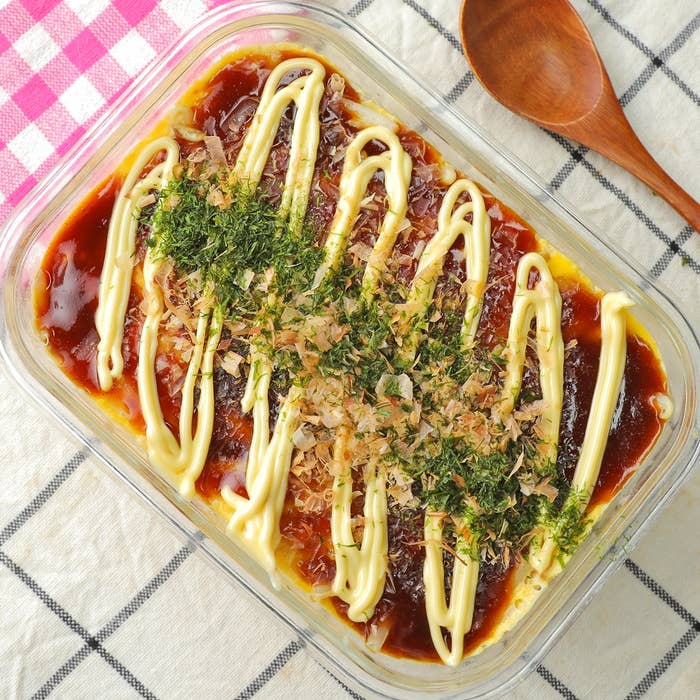 焼きそばの上にマヨネーズと青のりがトッピングされた料理がガラス容器に入っている。スプーンが横に置かれている。