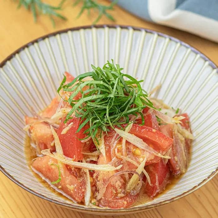 トマトとネギのサラダ、和風ドレッシングがかかった料理。