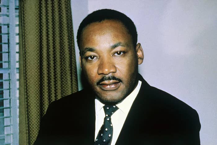 A person in a suit and tie is looking forward, with a calm expression