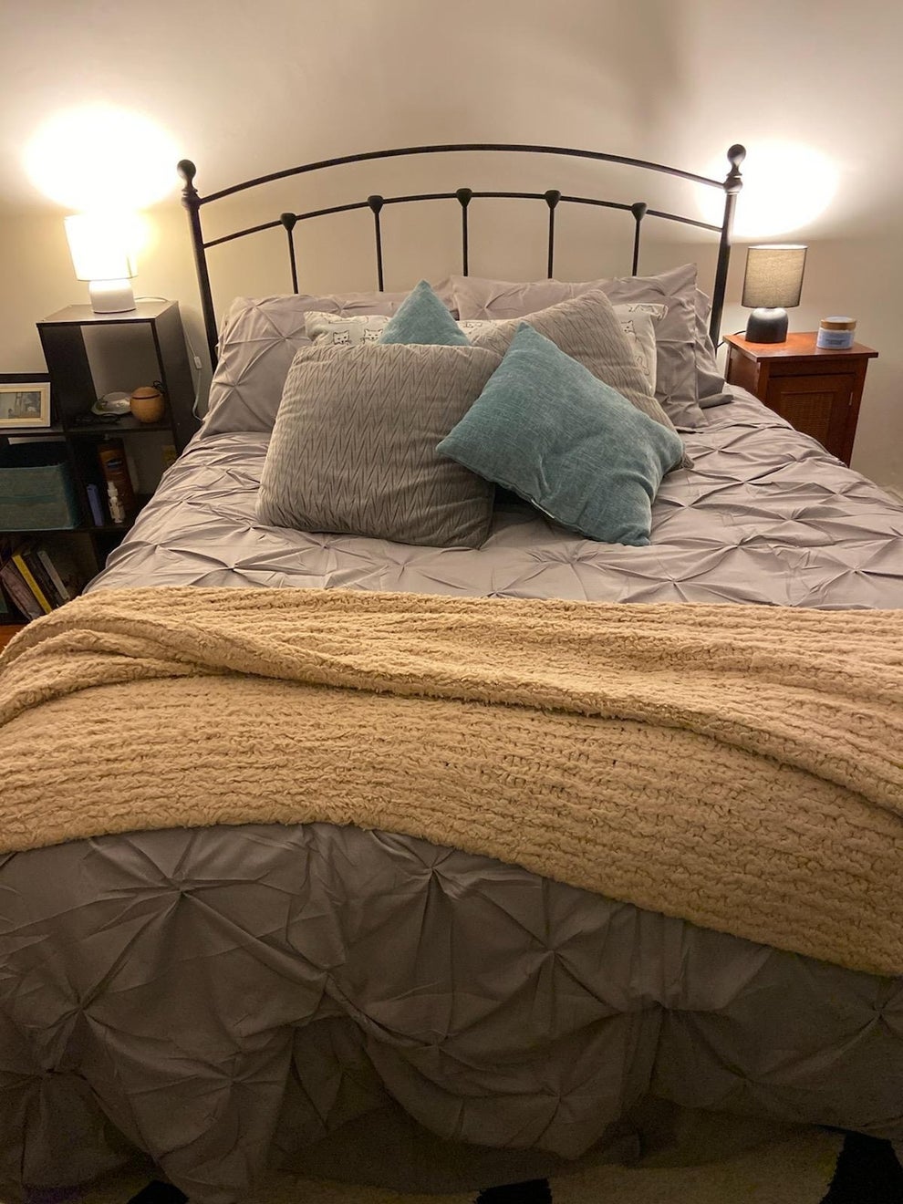 Cozy bed with decorative pillows and a textured blanket. Simple, inviting bedroom setup for a comfortable night's sleep