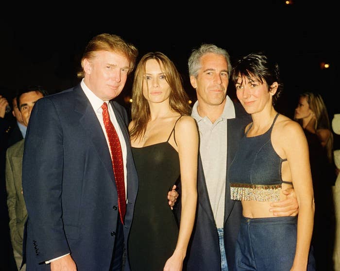 Four people posing together, elegantly dressed, at an event, with a formal atmosphere in the background