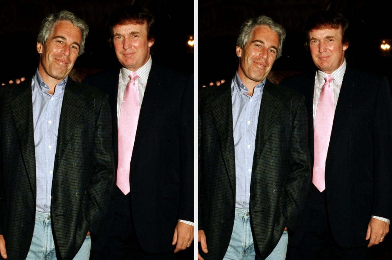 Two men in suits posing for a photo. One wears a pink tie, and both are standing casually with slight smiles