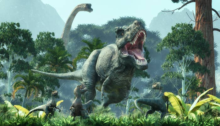 Dinosaurios en un paisaje selvático, incluyendo un T-Rex y varios velocirraptores entre vegetación y montañas al fondo