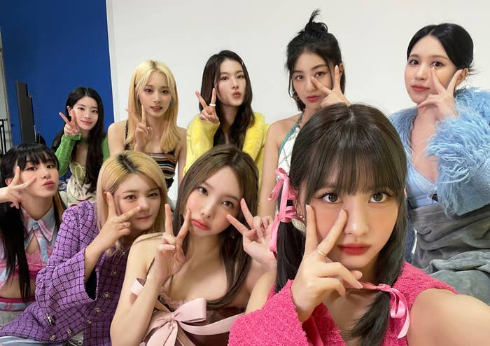 Grupo de nueve mujeres posa haciendo signos de paz con las manos. Varias estilos de moda moderna y peinados variados