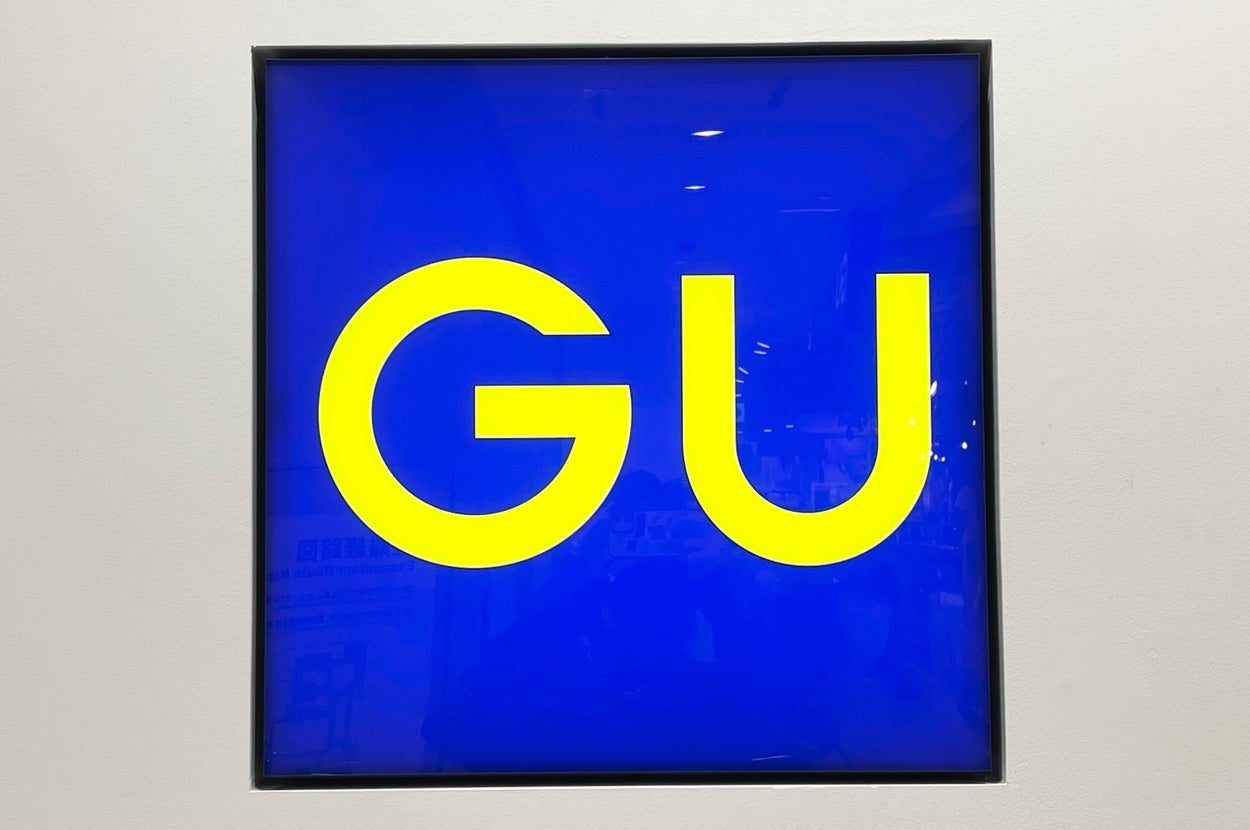Logo with bold yellow letters "GU" centered on a dark background, enclosed in a frame