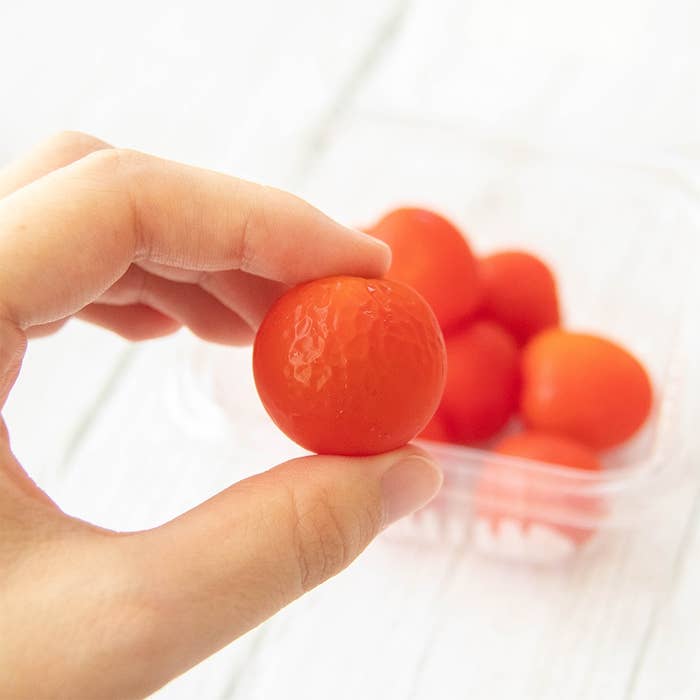 透明な容器に入った数個のミニトマトと、ミニトマトを手に持っている様子。