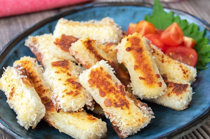 揚げずに焼いて作れるチーズを入れたちくわのフライが皿に盛られている。付け合わせのミニトマトと大葉がある。