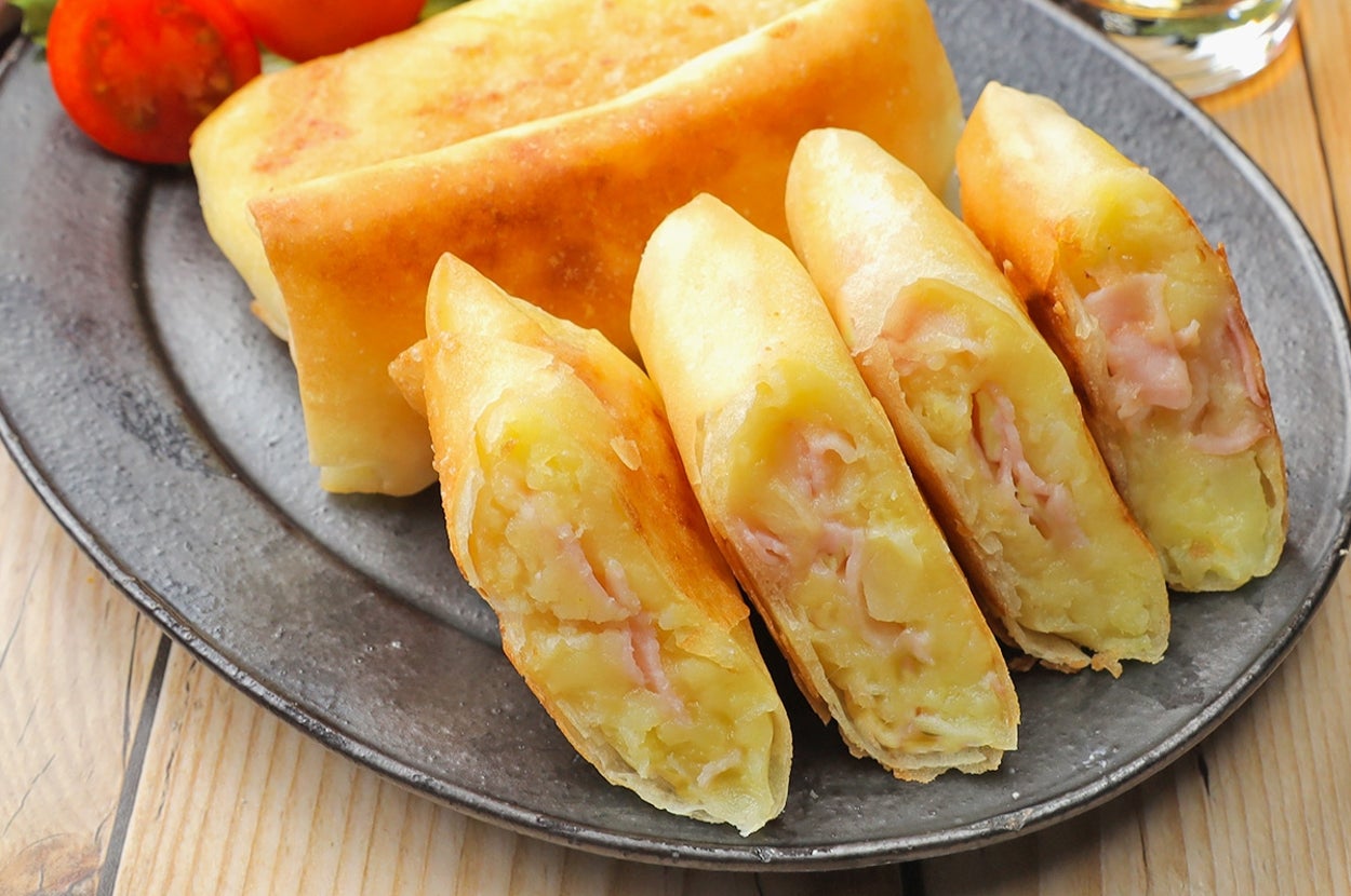 皿に盛られたチーズとハムの春巻き、サラダと飲み物が添えられている。