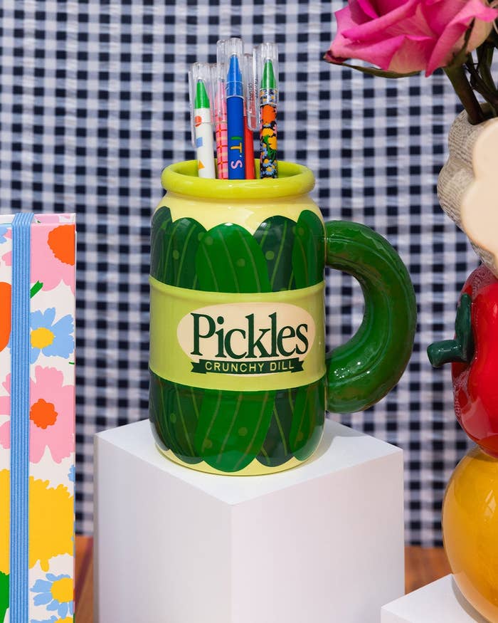 Pickle jar shaped mug with thick pickle shaped handle being used as a pen holder