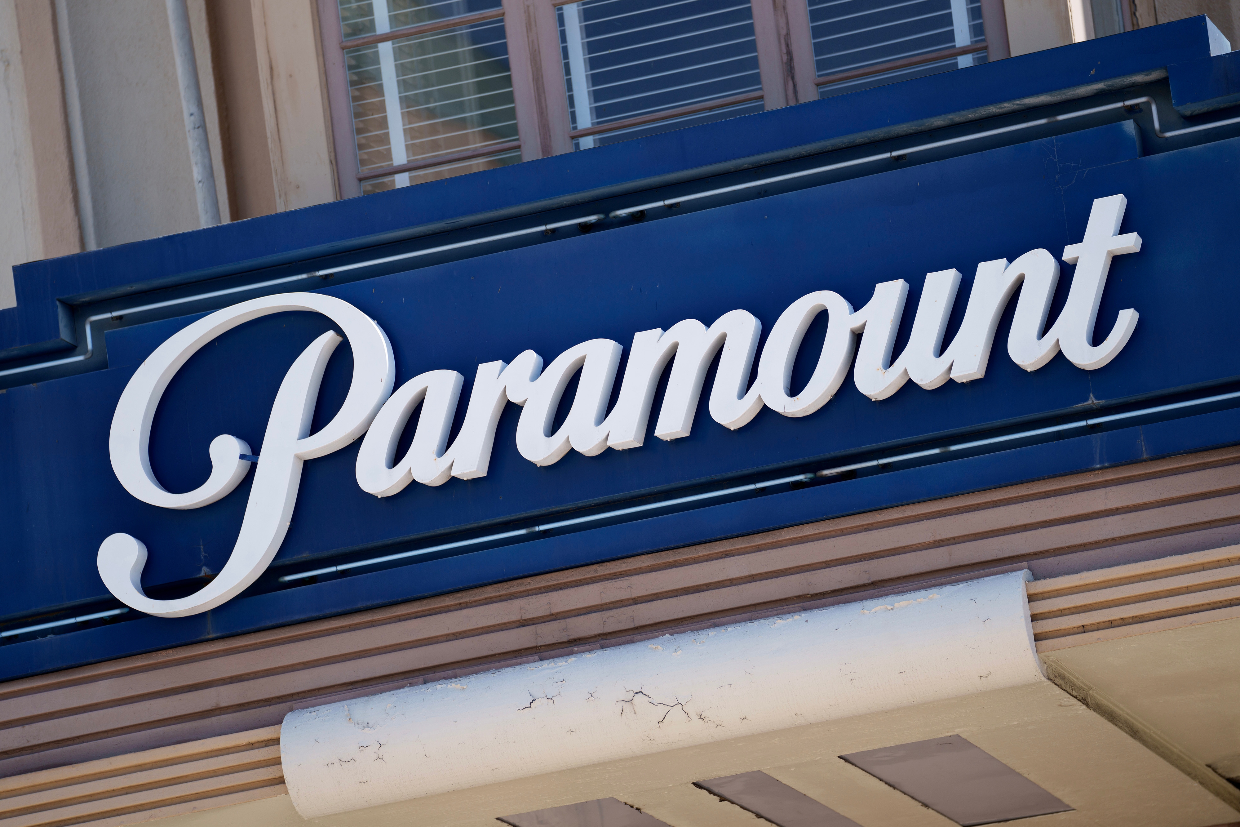 Paramount logo on a building facade, featuring sleek, cursive white lettering on a dark background