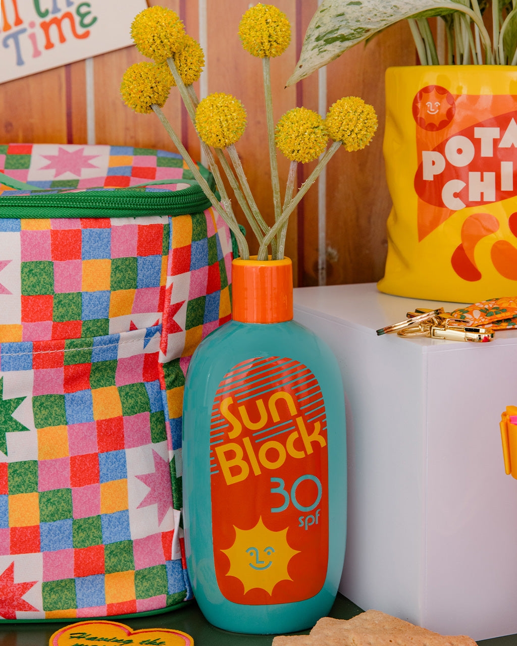 vase shaped like sunblock bottle with SPF 30 holding flowers