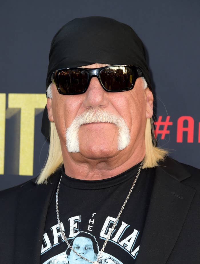 Person wearing a black bandana, sunglasses, and a graphic T-shirt under a black blazer, at a celebrity event