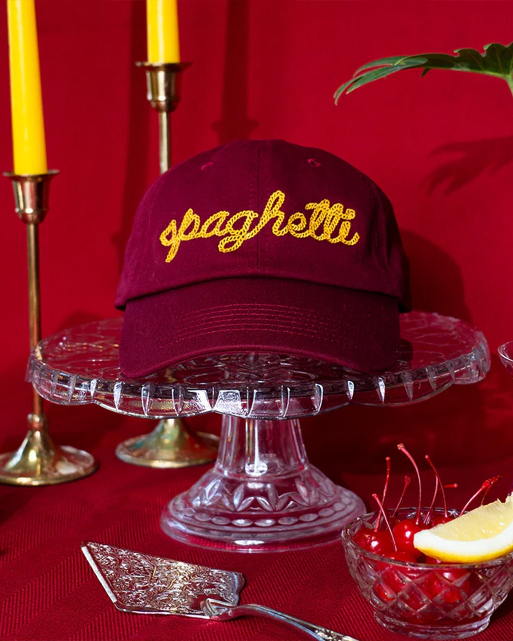 Maroon cap with "spaghetti" in yellow squiggle embroidered text