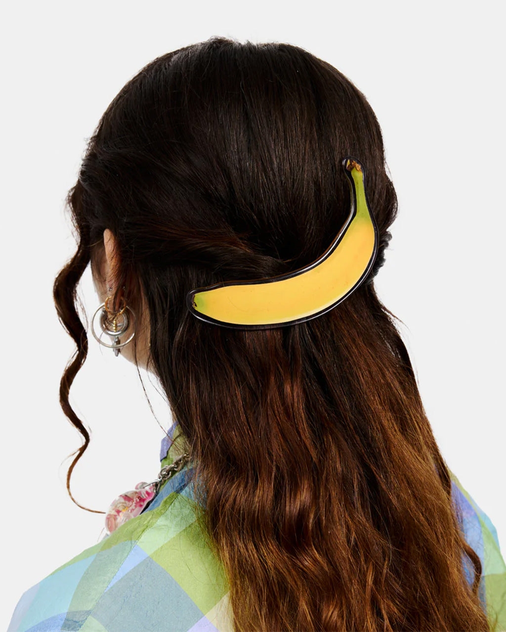model wearing a large banana-shaped hair clip to secure a half updo