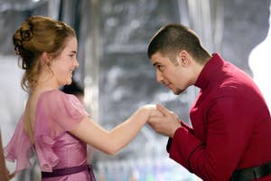 Emma Watson as Hermione and Stanislav Ianevskiin as Viktor in formal attire, with him holding her hand