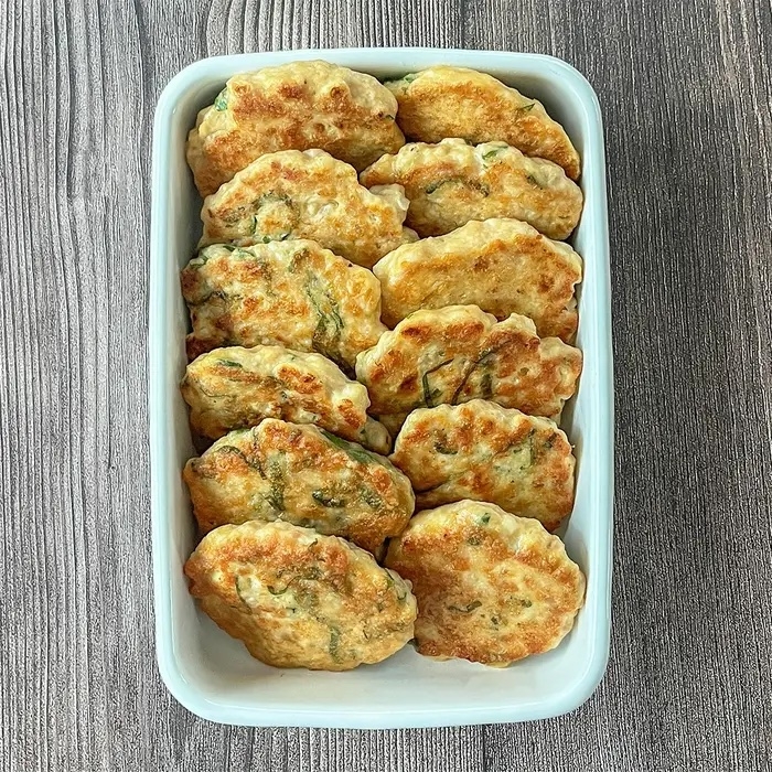 長方形の皿に盛り付けられた十数個の揚げたハンバーグ風の料理。