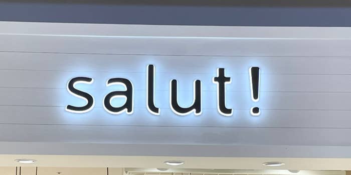 店舗の看板に「salut!」という大きなテキストがあります。