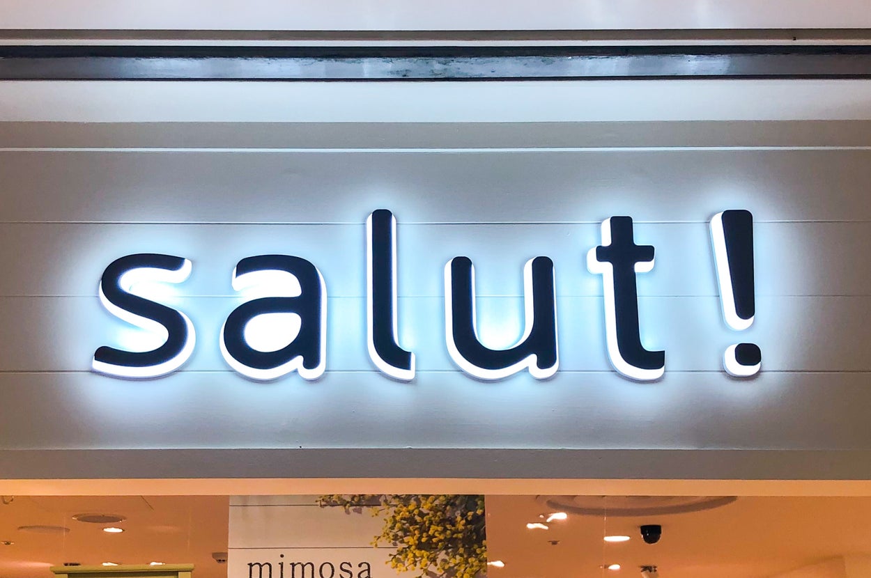 店内のディスプレイ。看板に「salut!」と書かれている。背景に様々なインテリア商品。