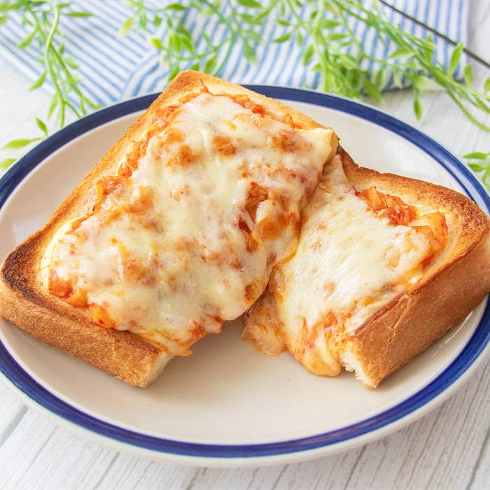 キムチとチーズがのったトーストが皿の上に置かれている。