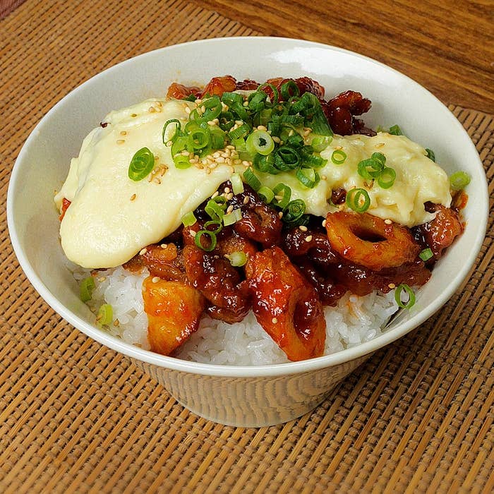 ボウルに盛り付けたご飯の上に鶏肉、クリーミーなソース、刻みねぎをトッピングした料理。
