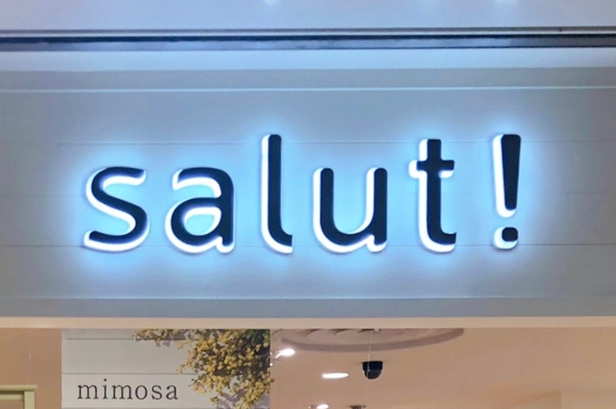 上部に「salut!」と書かれた店舗の看板が見える。店内の一部が見えている。