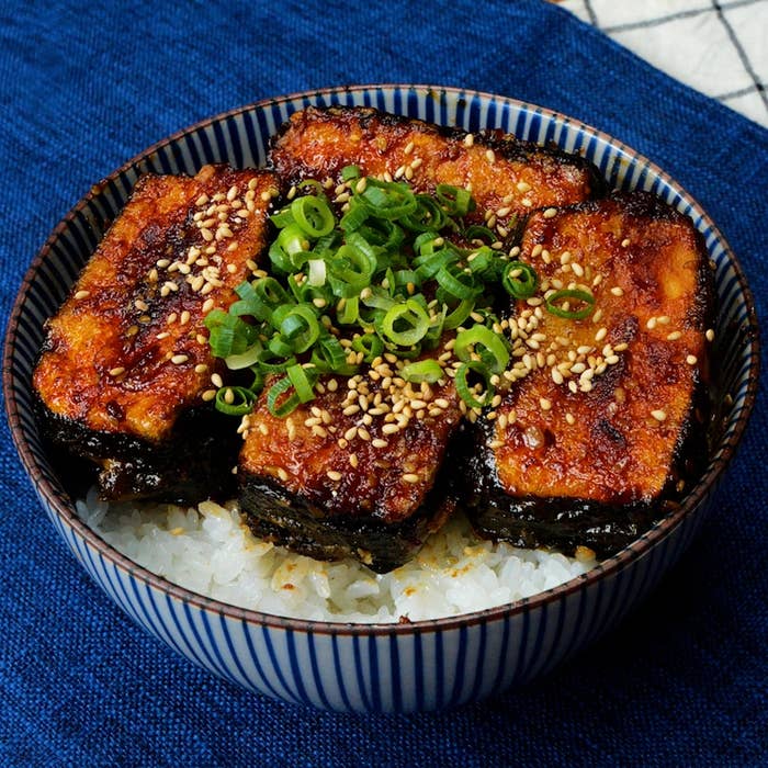 丼にのった焼き豆腐、ネギ、ゴマがご飯の上に盛られた料理。