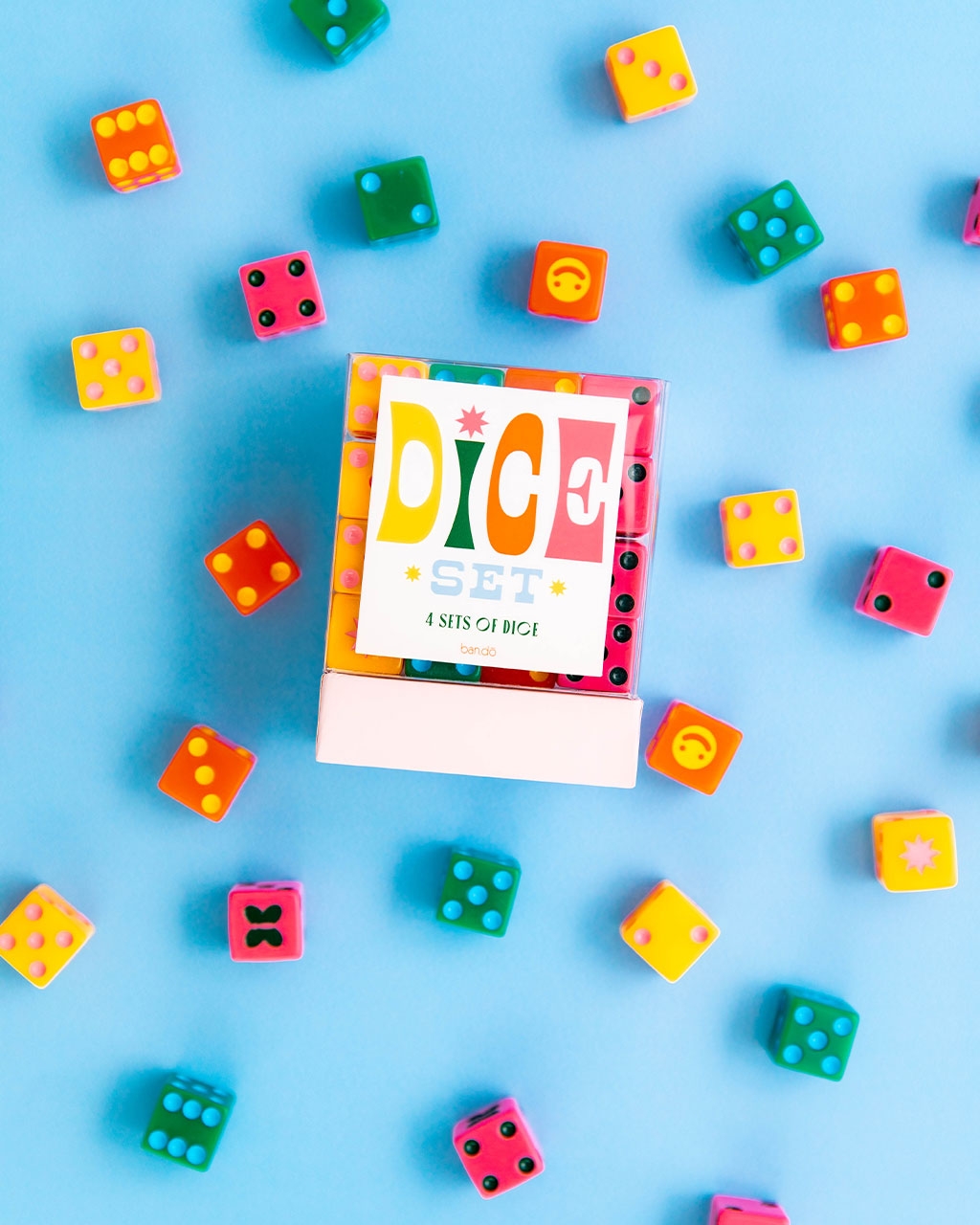 box of pink, orange, yellow, and green dice with contrasting dots and cute symbols like smiley faces and butterflies to represent ones
