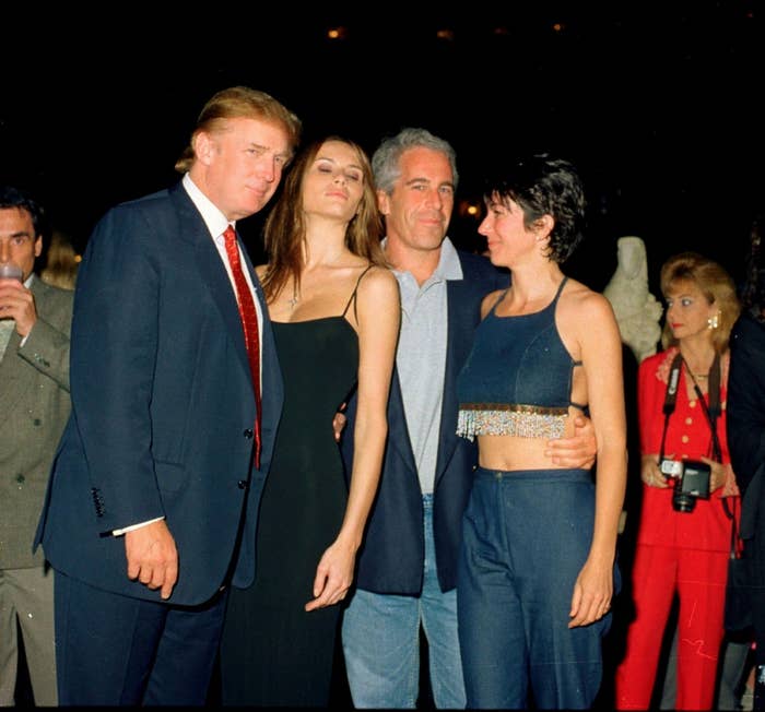 Four people pose at an event; two men in suits, flanking two women in evening attire