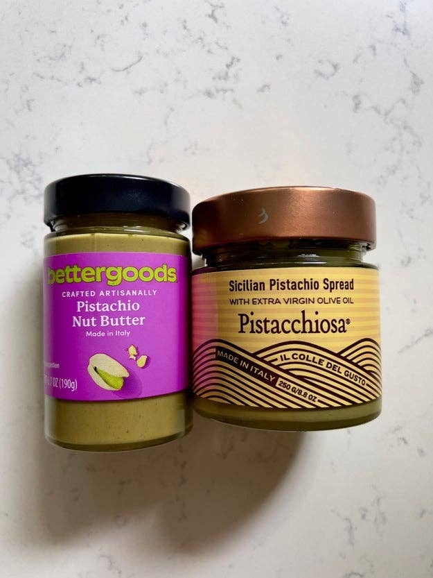 Two jars on a countertop: one is a pistachio nut butter, the other a Sicilian pistachio spread with extra virgin olive oil