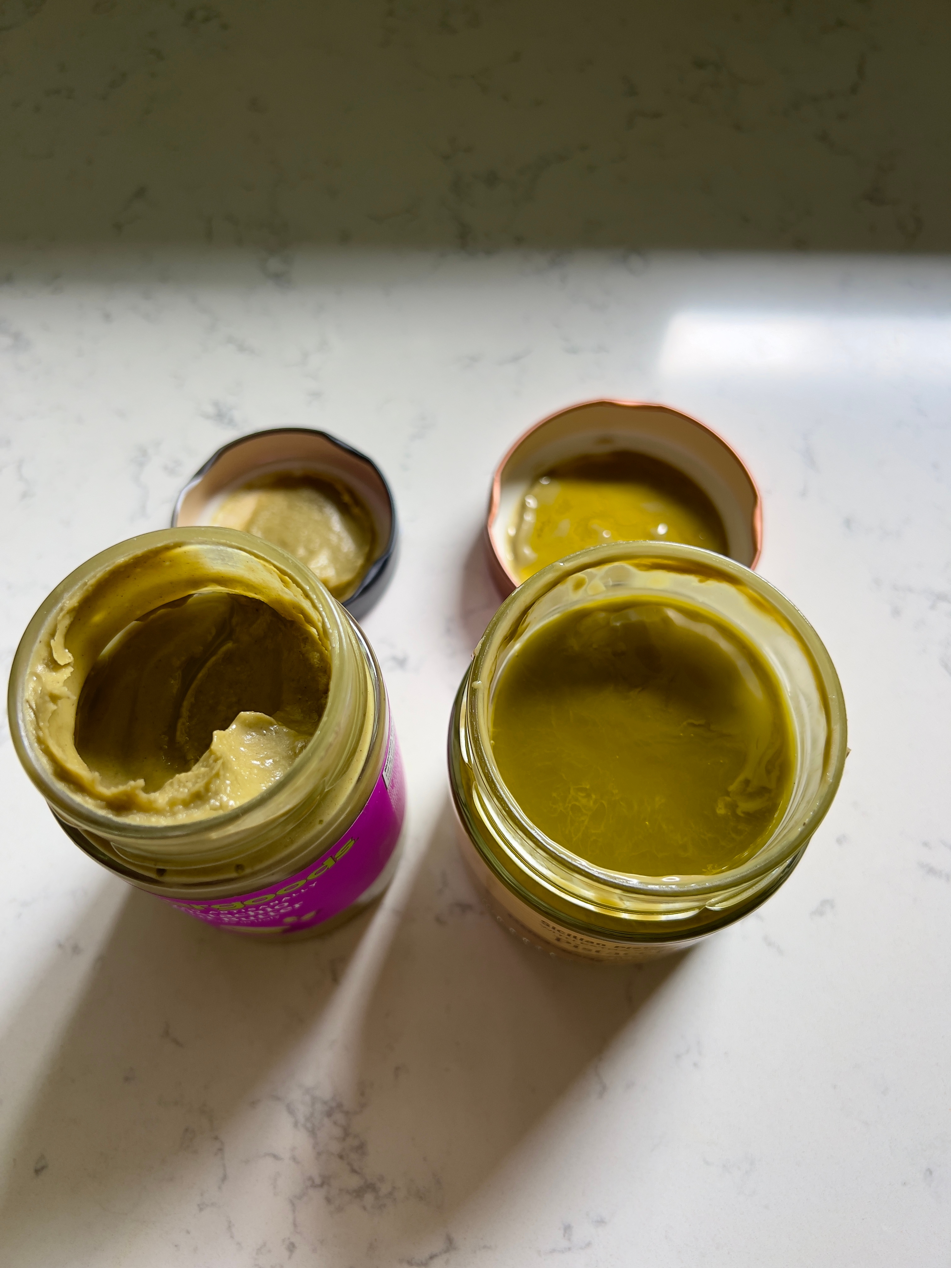 Two open jars of spread on a counter